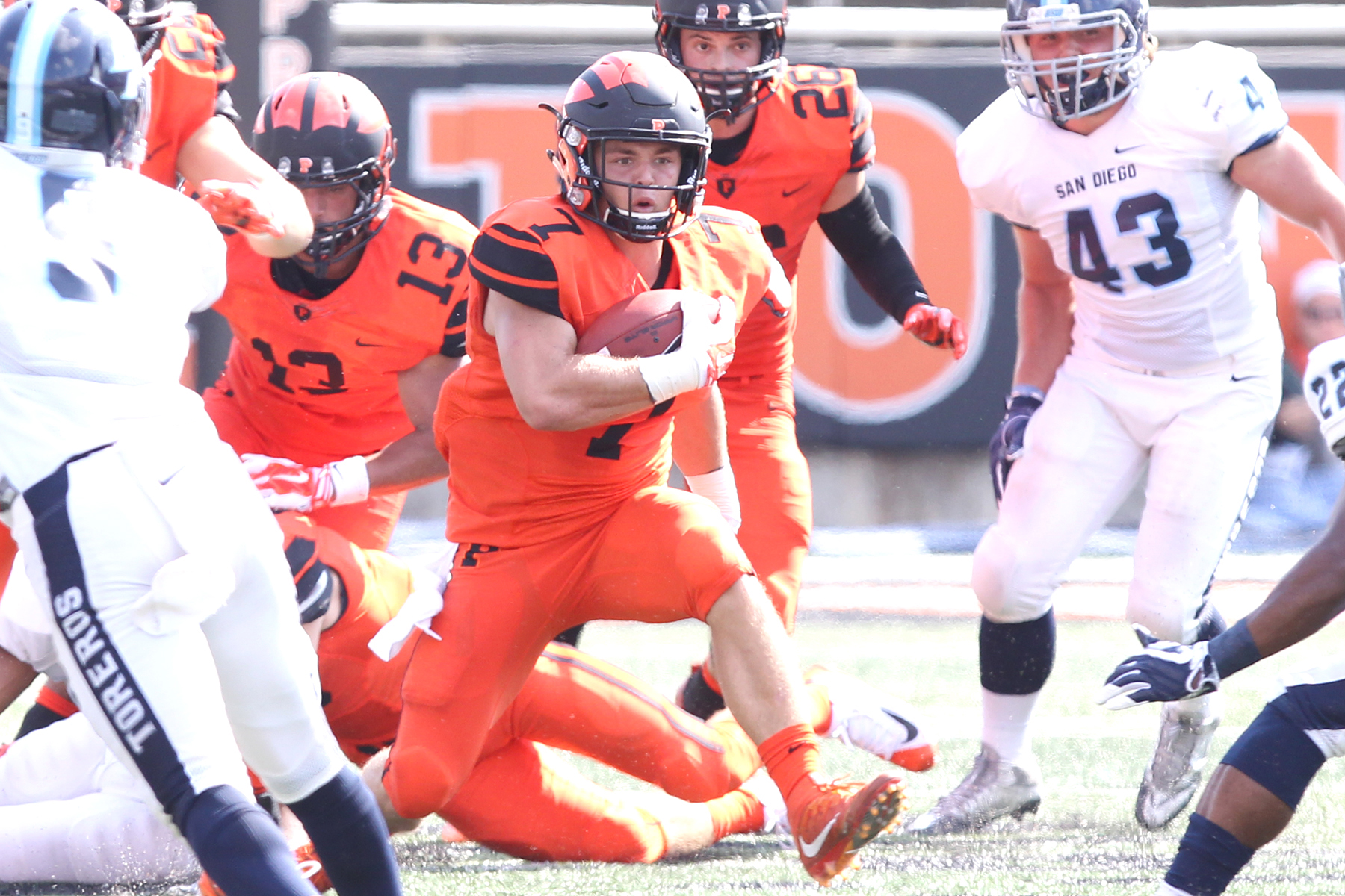 Tiger Bech ’21 runs during a football game holding the ball.