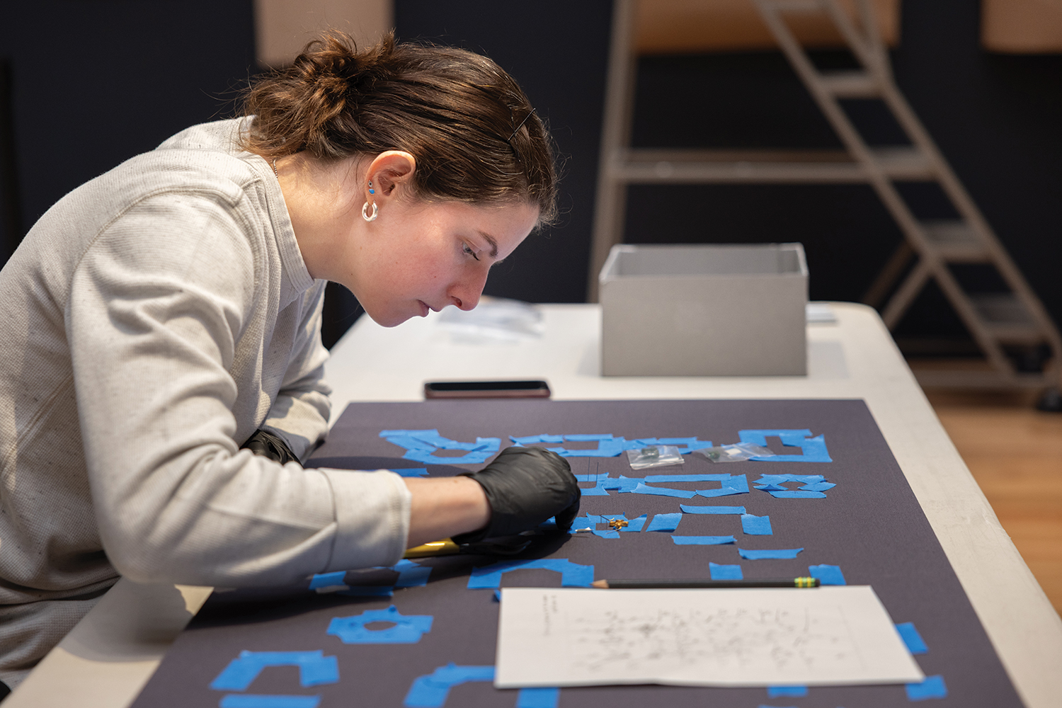 Courtney Kenny examines the installation plan for a case of objects.