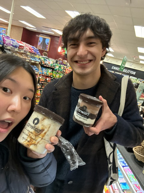 Lauren Blackburn ’26 and Kelly Kim ’26 take a selfie while holding pints of gelato in a convenience store.