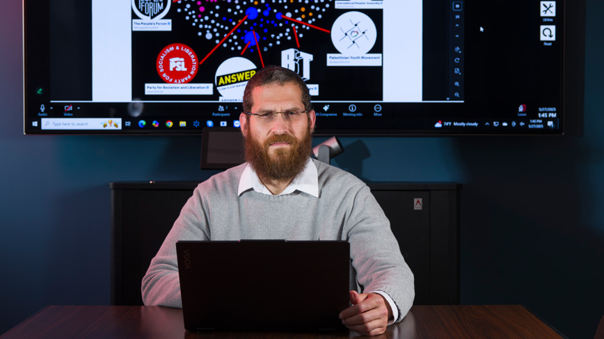 Joel Finkelstein in a dark room with the NCRI app running on a large screen in the background