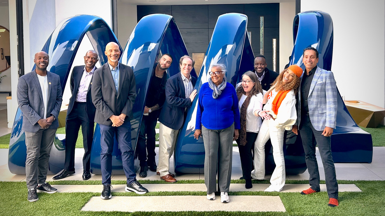 group of Princeton alumni who work with Kwanza Jones &rsquo;93 and Jos&eacute; E. Feliciano &rsquo;94 stand in front of a statue at their Pacific Palisades home