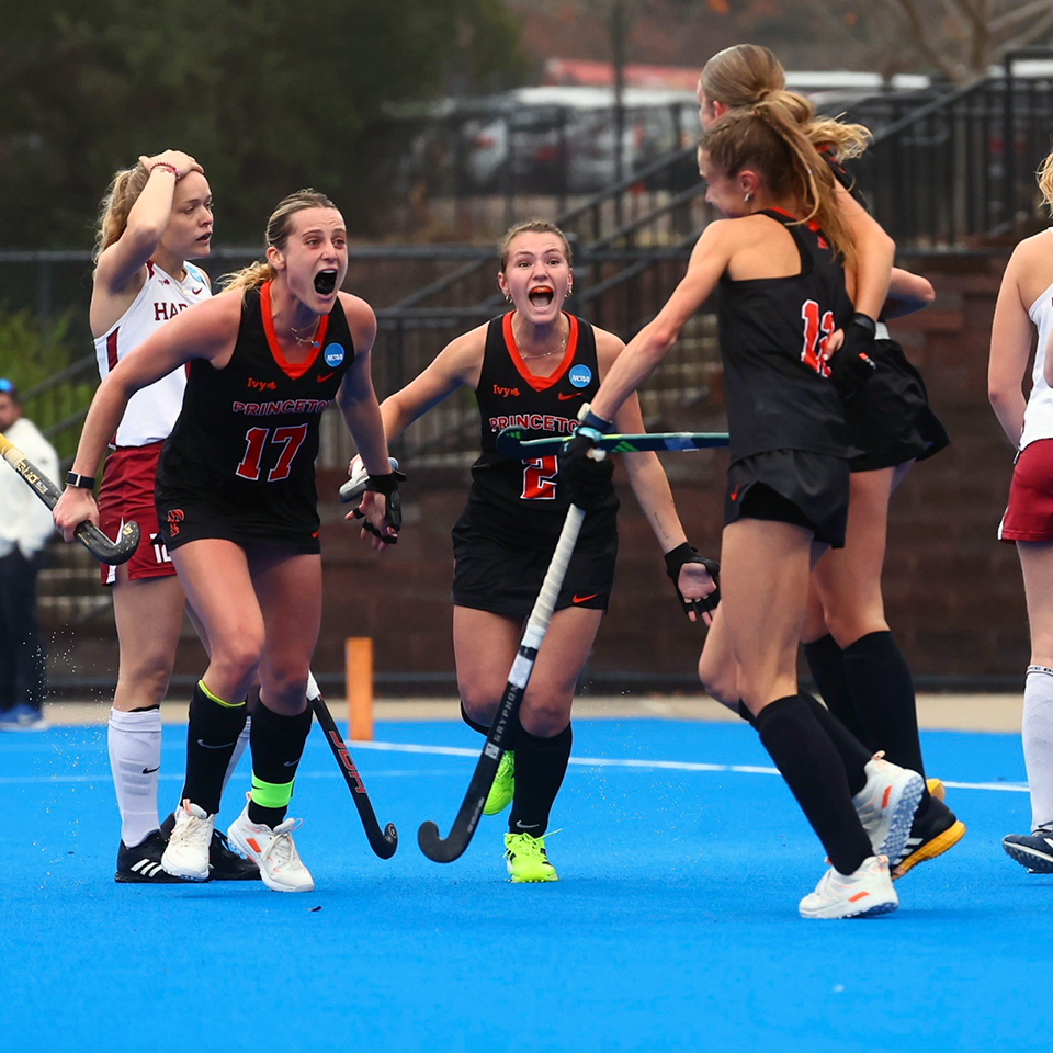 Field hockey players celebrate a goal