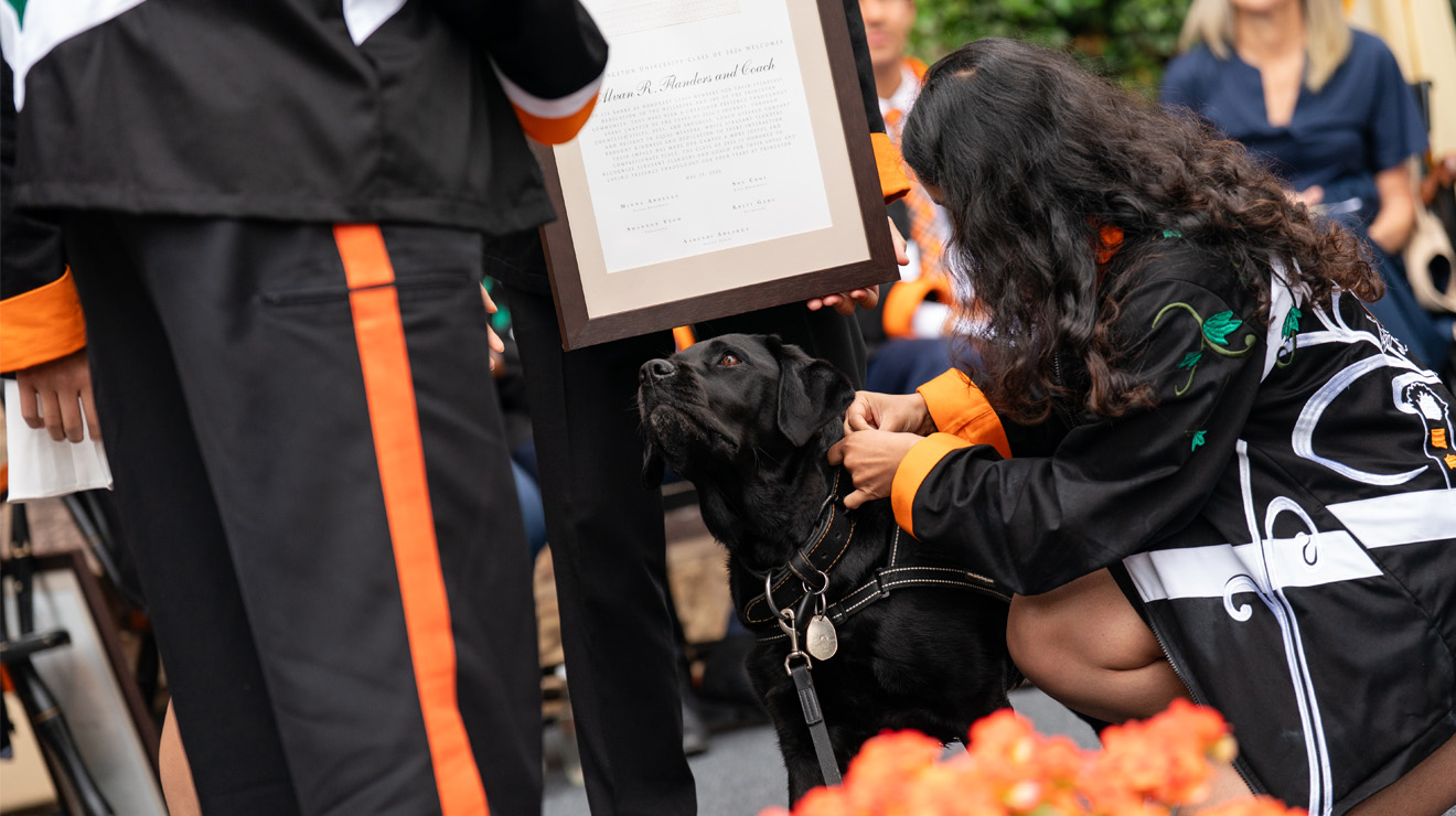 Coach-Class-Day.jpeg Someone fiddles with Coach's collar during the Class Day ceremony.