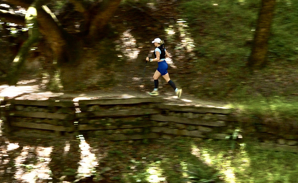 Sam Smart running on a trail through the woods