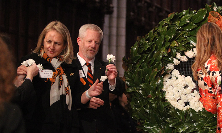 From left, Jennifer Daniels '93, Richard Holland '96 hold white carnations.