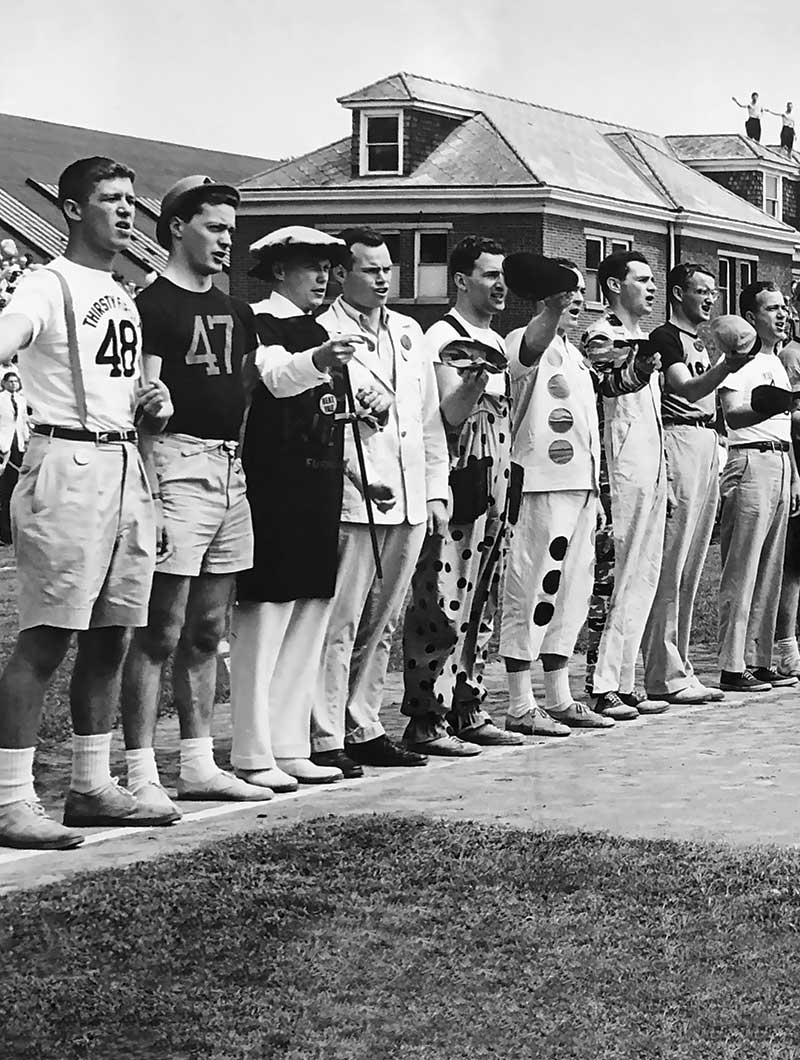 Students in a variety of costumes stand shoulder-to-shoulder and sing at the Princeton-Yale baseball game, Reunions, 1949.