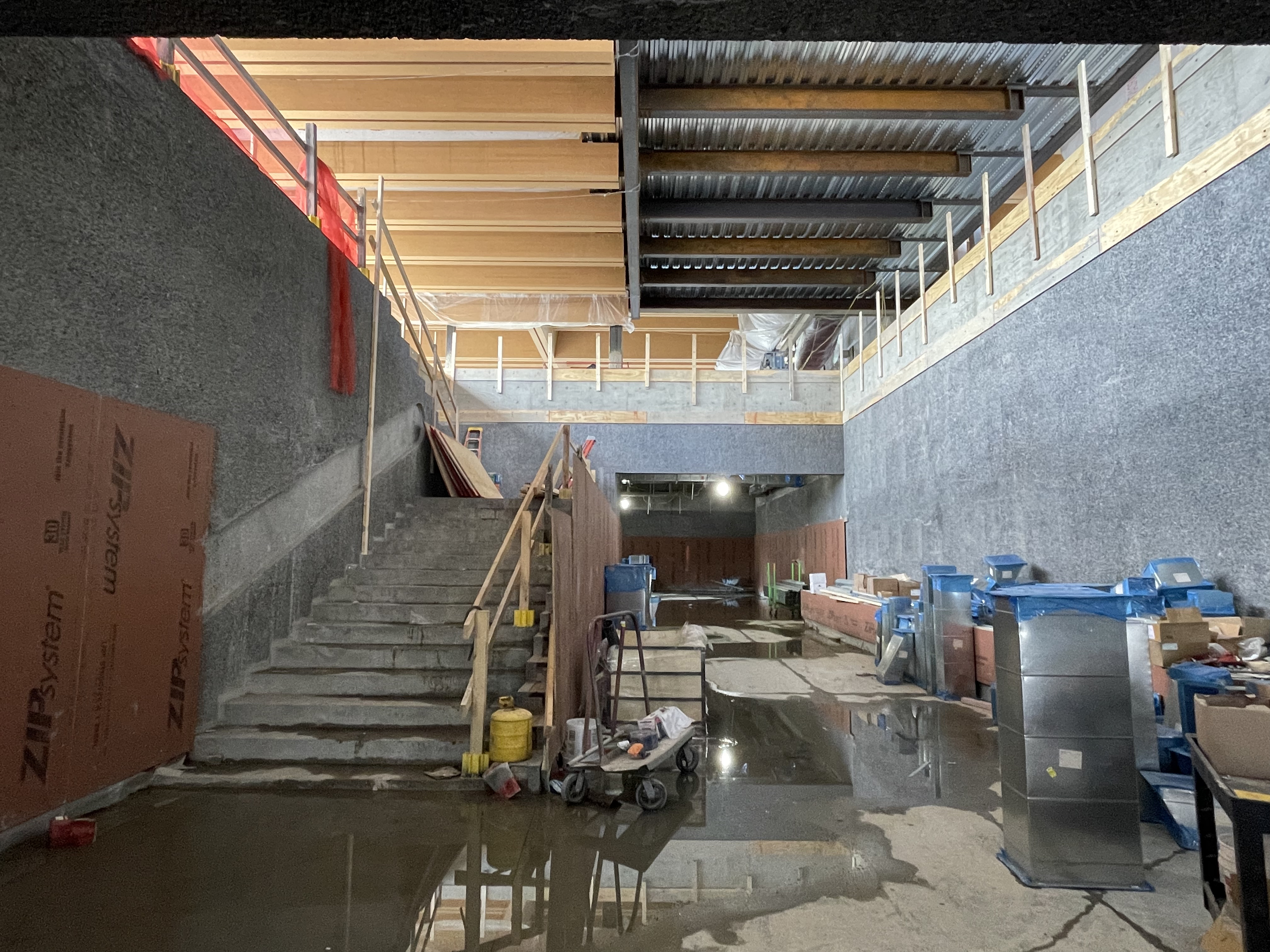 The inside of the art museum under construction, with gray stone or concrete walls.