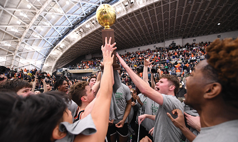 Team lifting up a trophy on the court