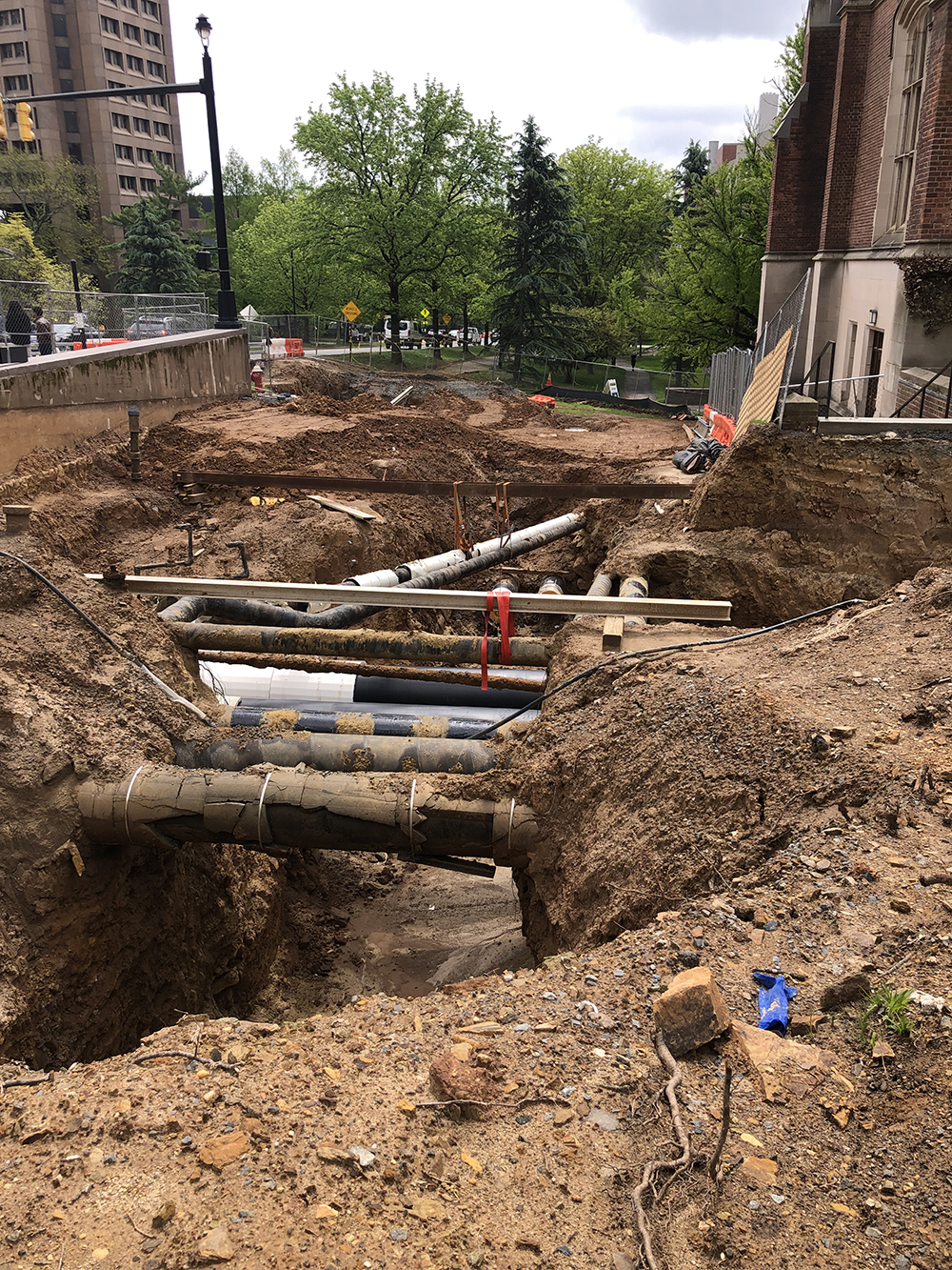 Pipes criss-cross an open trench.