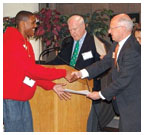Henry Von Kohorn '66, second from right, assisted by Brian Breuel '66 and Marguerite Vera '79, recognize Princeton Prize winner Sidney Johnson during a race-relations symposium on campus.