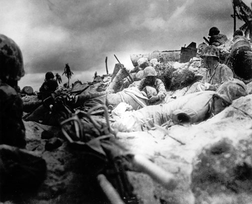 Marines, many of them wounded, take cover behind a sea wall on Red Beach No. 3 during the initial landing at Tarawa Nov. 20, 1943.