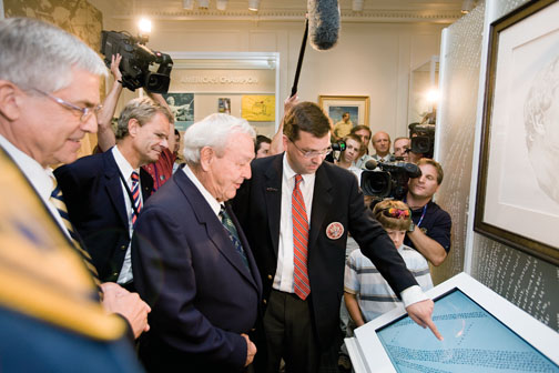 Rand Jerris *99, center, shows an interactive display of the portrait “Gratitude” to Arnold Palmer at the USGA Museum’s reopening in June 2008.