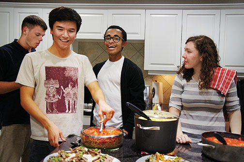 From left, Ryan Fulmer ’16, Nicholas Sexton ’17, Joshua Taliaferro ’15, and Kate Maffey ’16 help prepare a meal for families of veterans receiving medical treatment in Washington, D.C.