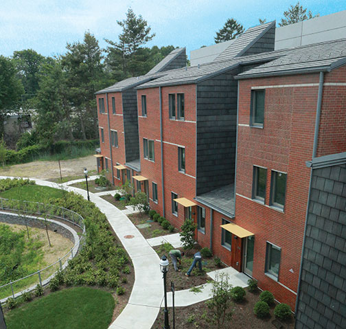 A curving walkway connects townhouse units.