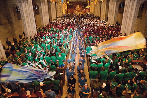 Students wearing the colors of their residential colleges fill the Chapel for Opening Exercises.