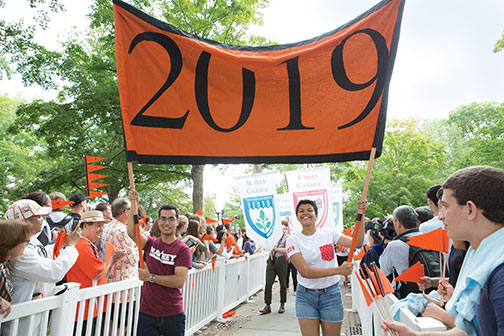 Josh Faires ’19 and Victoria Davidjohn ’19 carry the banner for the Pre-rade as the class is welcomed by other students and alumni.