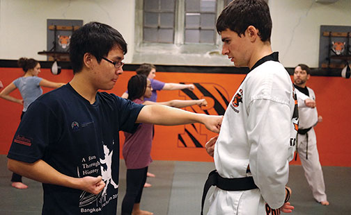 Joe Rummanthorn ’18, left, learns to aim a punch from taekwondo instructor Matthew Weinberg, a postdoc.