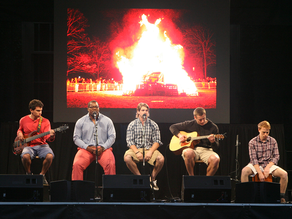 Football stars Caraun Reid '13 and Roman Wilson '14, second and third from left, respectively, led a rendition of "Ain't No Mountain High Enough," with an image of the Big Three bonfire in the background.