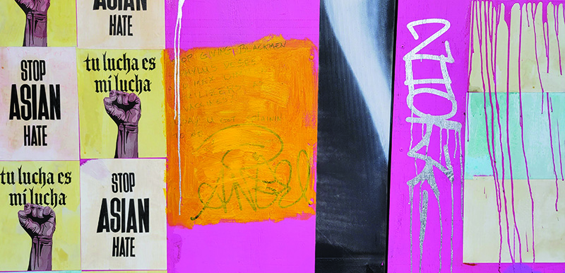 Stop Asian Hate posters on a graffiti wall.