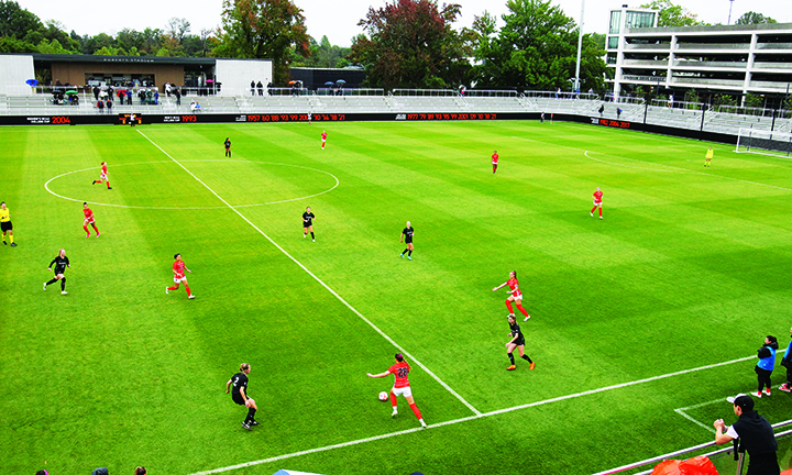 Women’s soccer players are scattered around the soccer field.