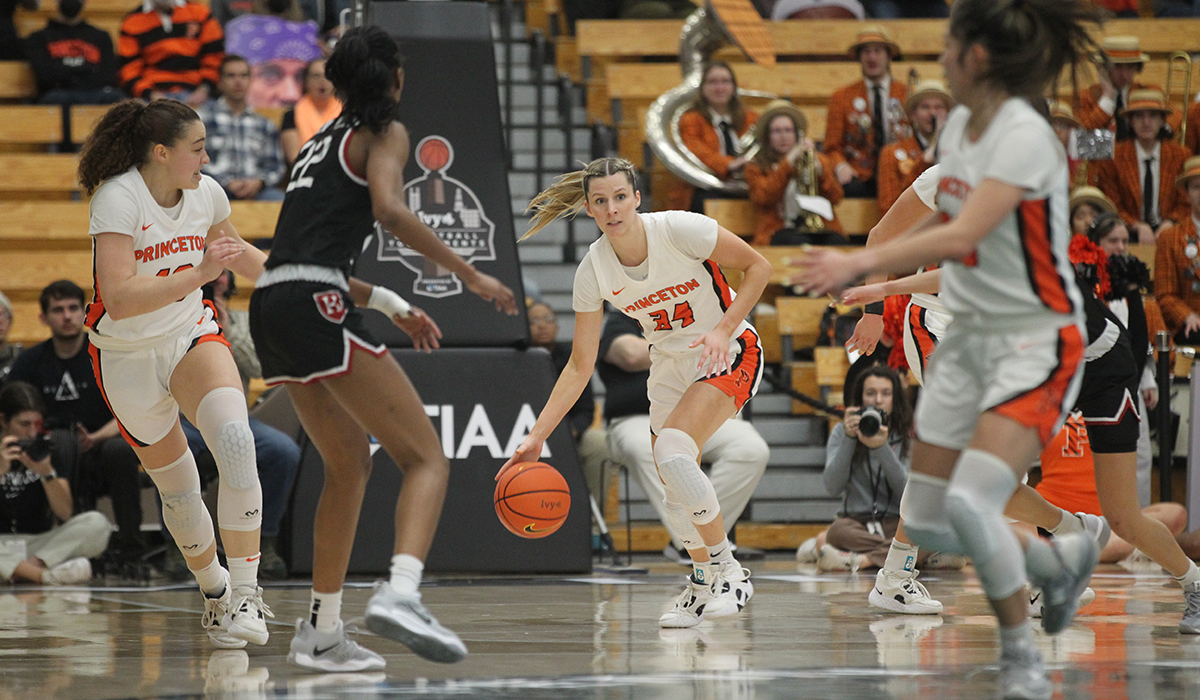 Julia Cunningham dribbles with players to her right and left.