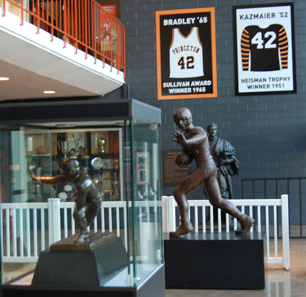 The lobby at Jadwin Gym includes, from left, the 1951 Heisman Trophy, a life-sized representation of Kazmaier in bronze, and a banner featuring his famous No. 42 jersey (next to Bill Bradley '65's jersey). 