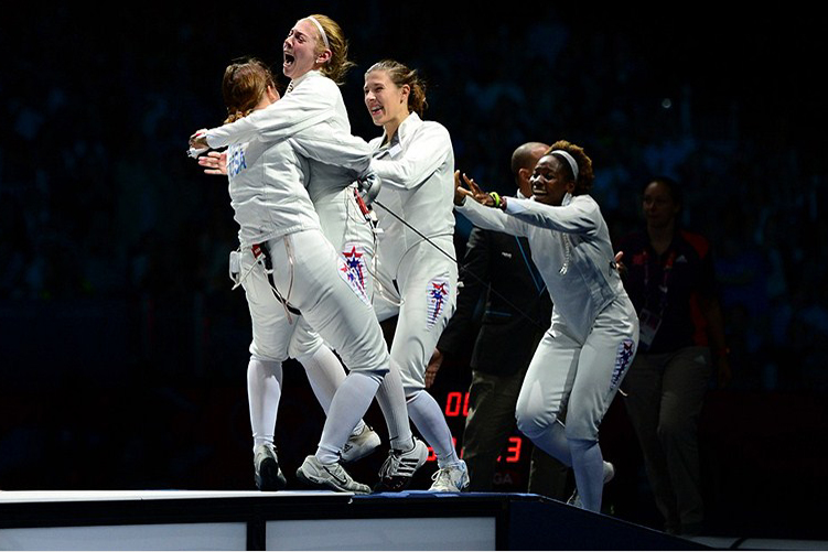 Aug. 4: Susie Scanlan '14, second from left, and Maya Lawrence '02, right, joined the celebration after Courtney Hurley, left, scored a touch in overtime to lead the United States over Russia in the women's team epee bronze-medal match. 