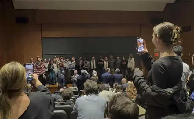 Attendees crowd the stage during an emotional moment during a speech by the former prime minister of Israel.