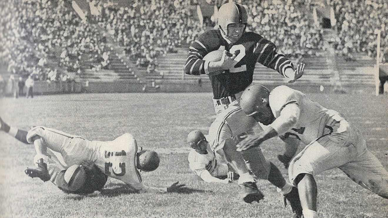 Football player Dick Kazmaier '52 tries to dodge a tackler in 1951