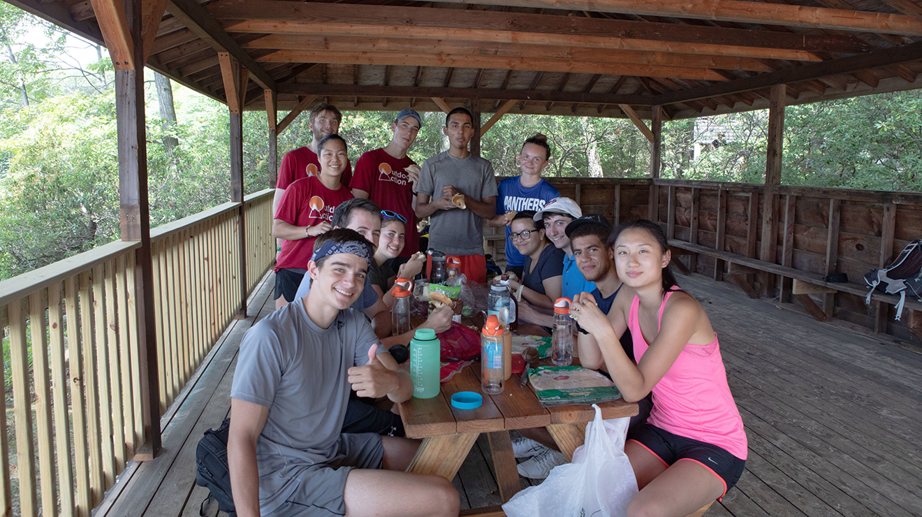 Hiking group gathered around a picnic table