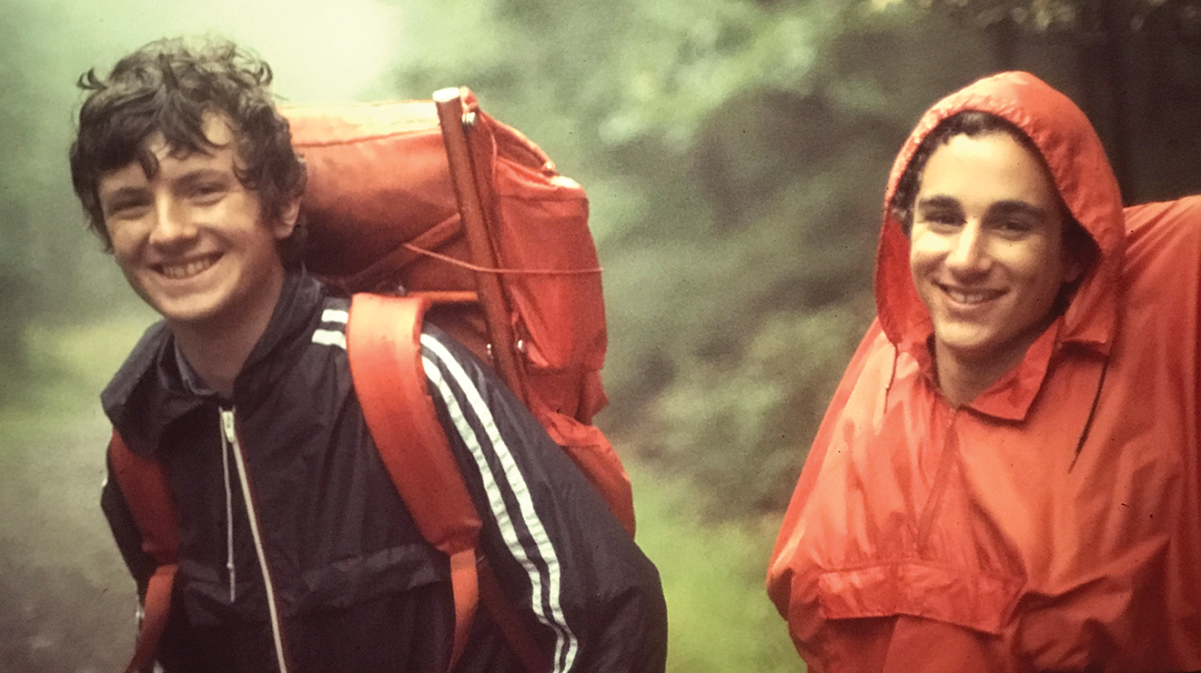 One hiker with a backpack and another in rain gear