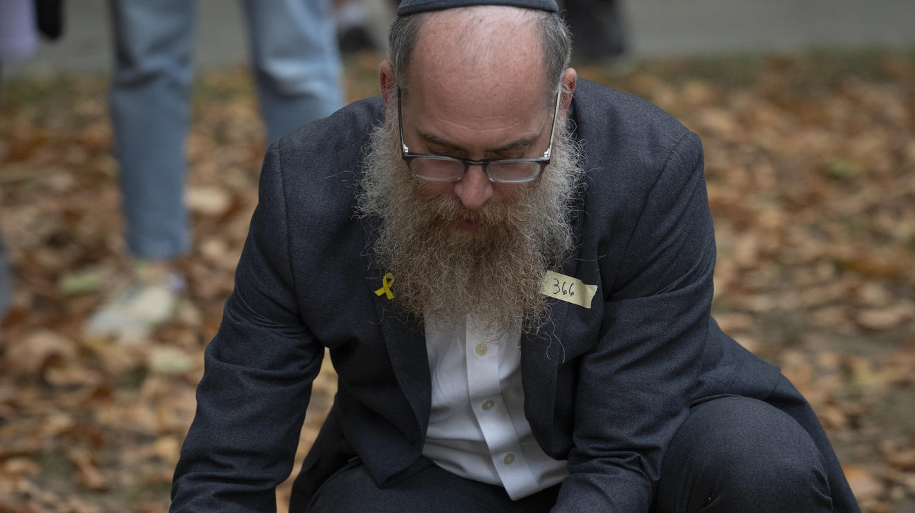 Rabbi Eitan Webb, co-director of the Scharf Family Chabad House, places flowers on the North Frist Lawn.