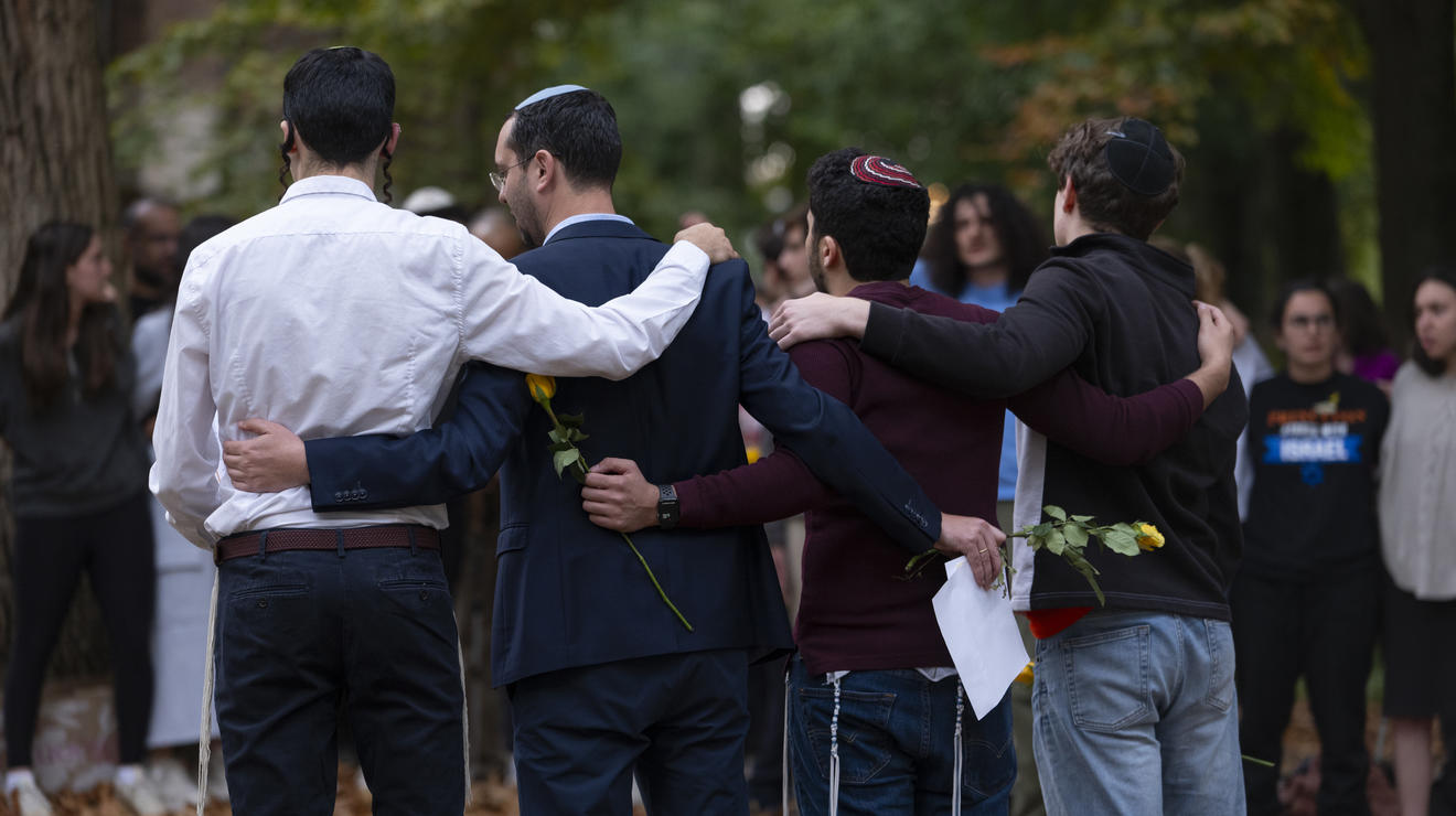 Mourners embrace on the Frist North Lawn to pray and sing