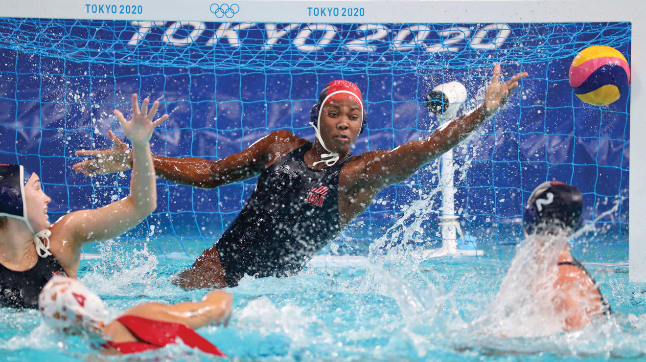 Ashleigh Johnson ’17 jumping out of water to save a goal during the Tokoyo Olympics