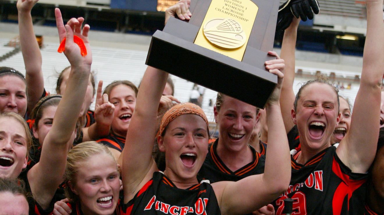 Rachael Becker DeCecco ’03 celebrating and holding up the NCAA trophy