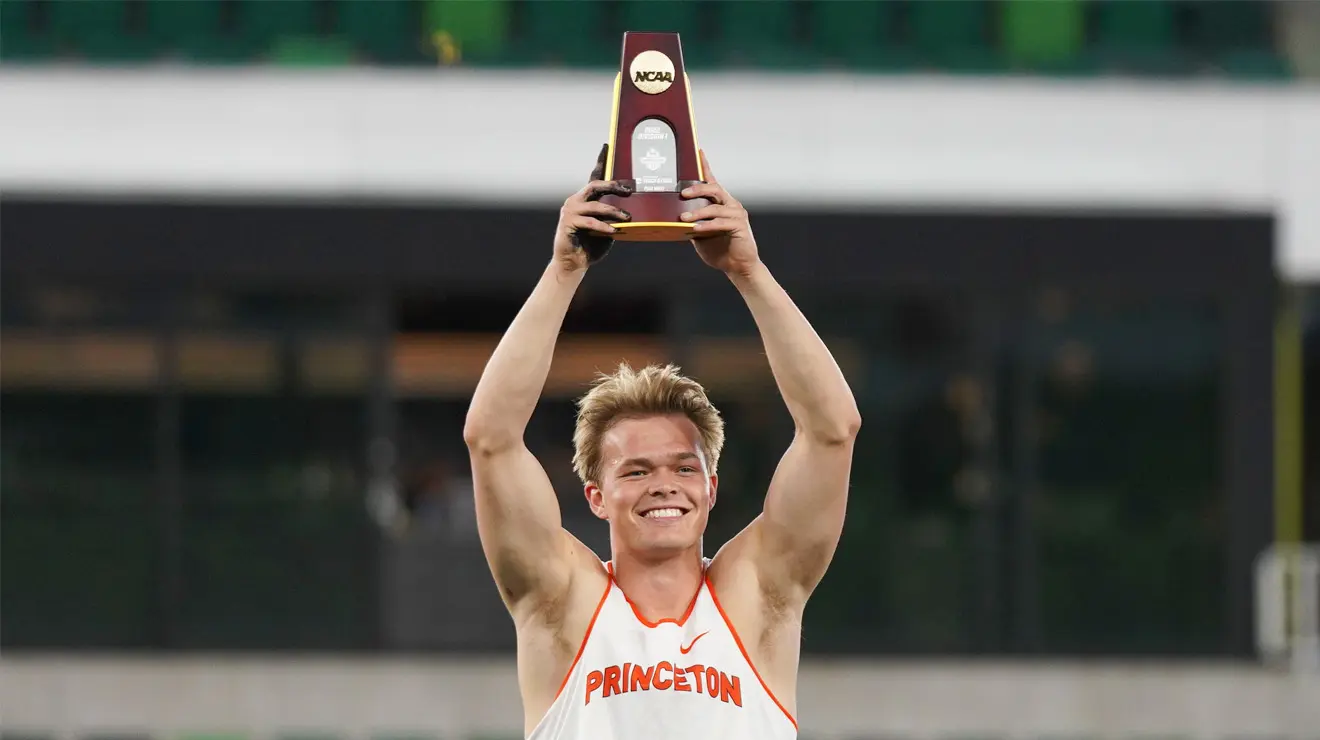 Sondre Guttormsen ’23 celebrates holding up the NCAA trophy