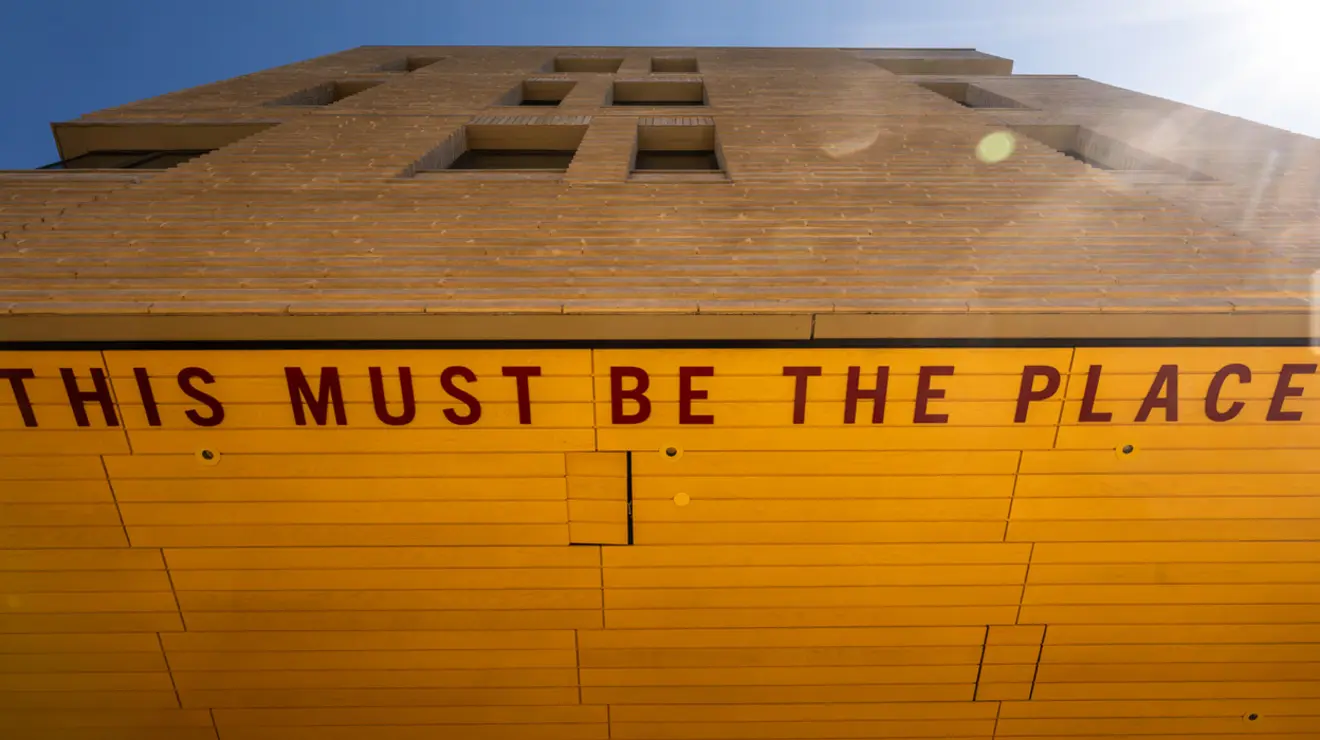 EVOLVING GALLERY_Yeh_NCW 2.jpg Architectural detail of Yeh College showing the underside of an overhang decorated with bright yellow tiles and the words This Must Be the Place in red letters written on the ceiling
