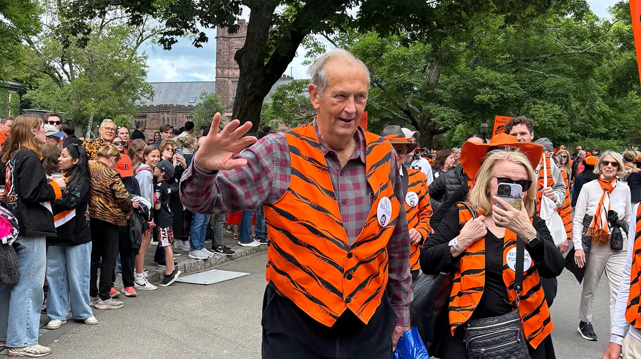 Wearing a tiger-striped vest, Bill Bradley ‘65 waves while walking in the 2025 P-rade.