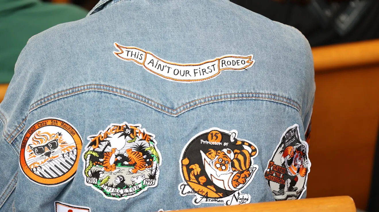 The back of a jean jacket with Reunions patches and one that reads "This ain't our first rodeo."