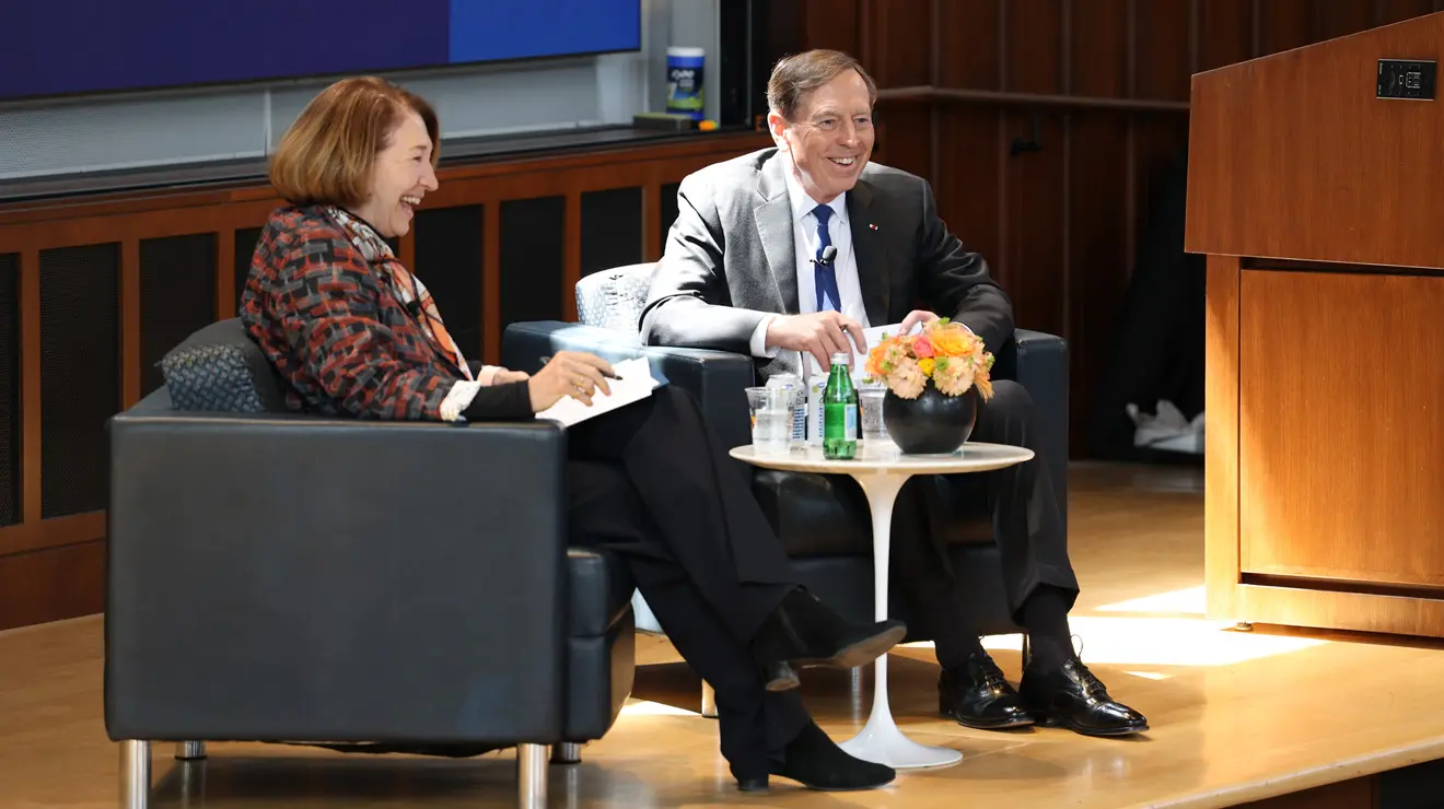 General David Petraeus and Anne-Marie Slaughter sit in chairs on a stage.