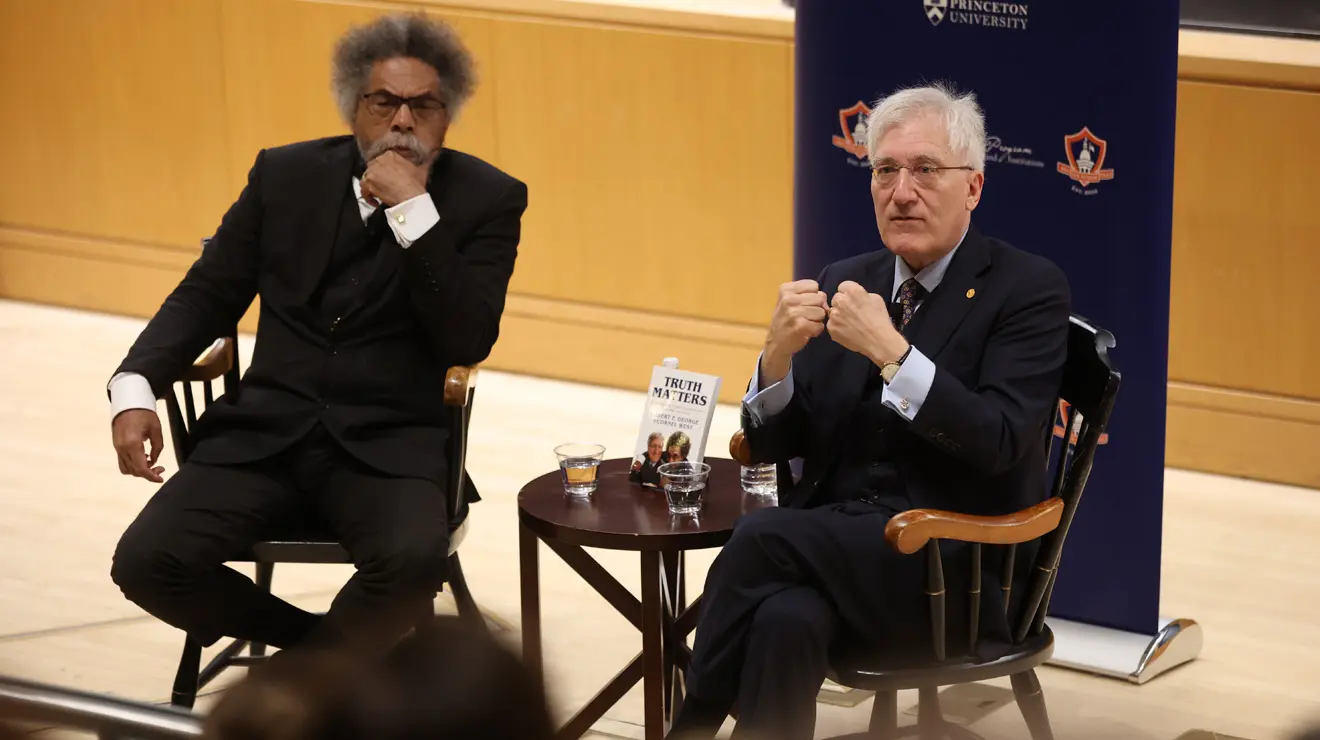 Cornel West and Robert George sit on stage during their Reunions panel.