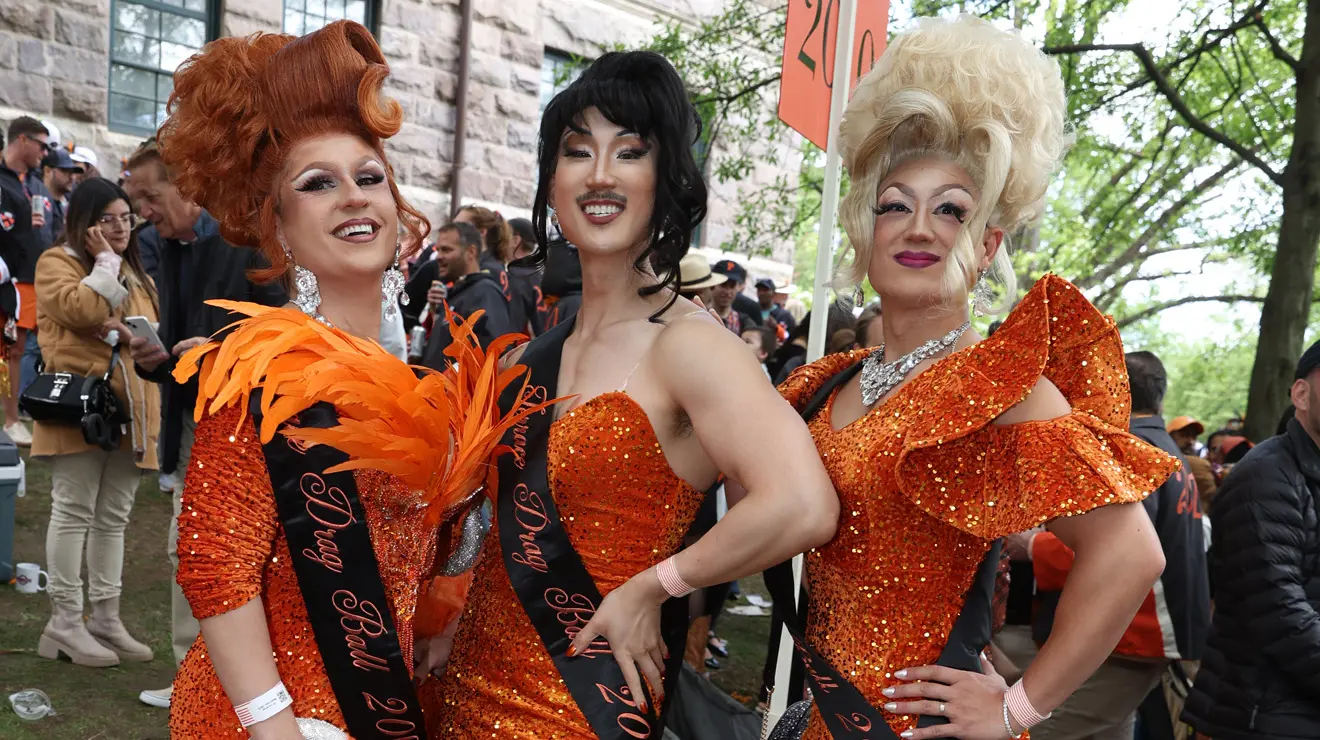 Three drag queen wear orange at the P-rade.