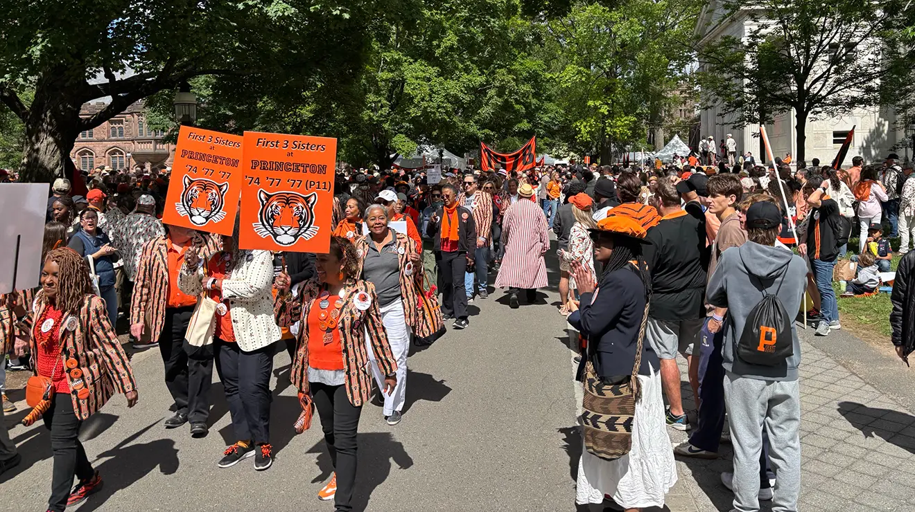 People carry two orange signs with illustrations of tigers in the P-rade.
