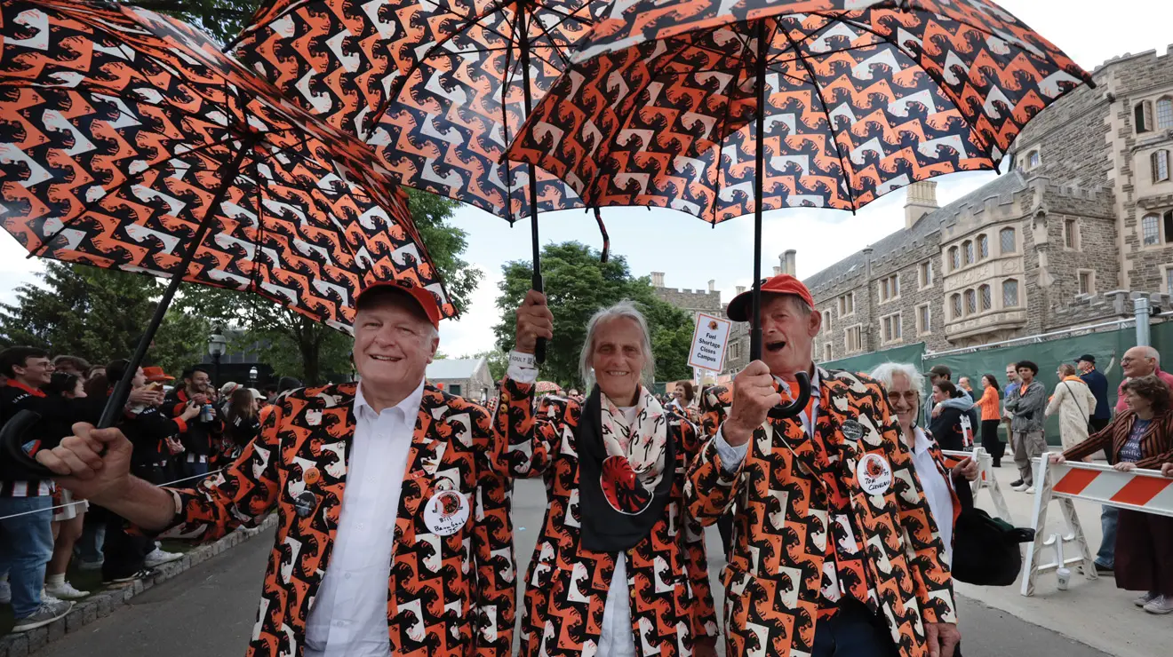From left, Bill Baumbach ’75 *87, his wife Gail Baumbach, and Tom Cleveland ’75 sport umbrellas, vests, and shorts matching their class jacket, all of which were designed by Gail Baumbach in 2000.