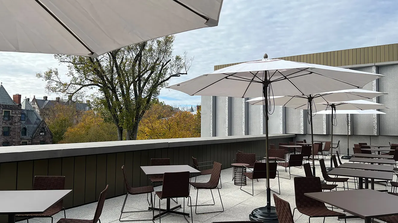 ARTMUSEUM_Mosaic_outside.jpg An outdoor dining area is filled with tables and white sun umbrellas.