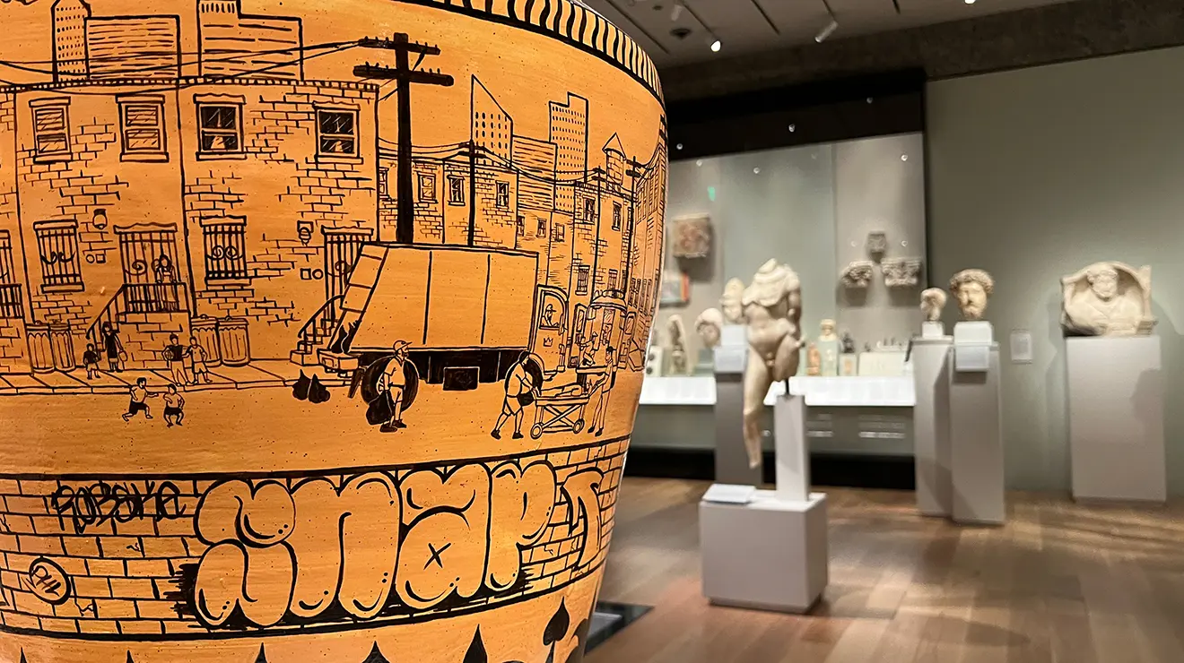 ARTMUSEUM_Urn_ancient_art_0.jpg A red urn with a black illustration of a garbage truck in a cityscape; the word SNAP appears in bubble letter graffiti.