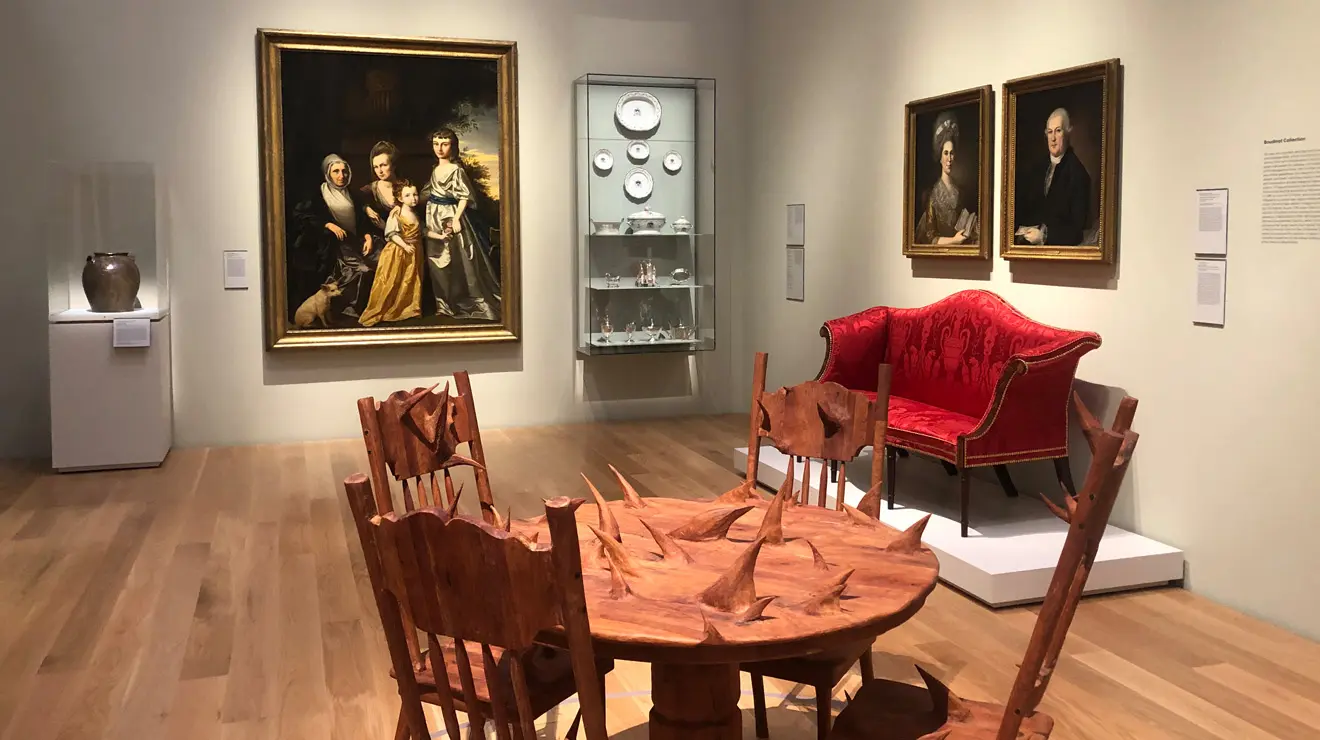 ART_Hugh Hayden_America.jpg Hugh Hayden's (Born 1983) America, 2018. "America is based on a kitchen table I grew up with, a type popular in Texas in the 1980s and '90s. Conceptually, the round tabletop provides everyone in a "nuclear family" a seat at the table. The chairs are derived from turn-of-the-century pressback chairs that, compared to more common utilitarian chairs, allowed the masses the luxury of a design that was both ergonomic and decorative. The table is crafted from mesquite wood, a tree indigenous to the southwestern U