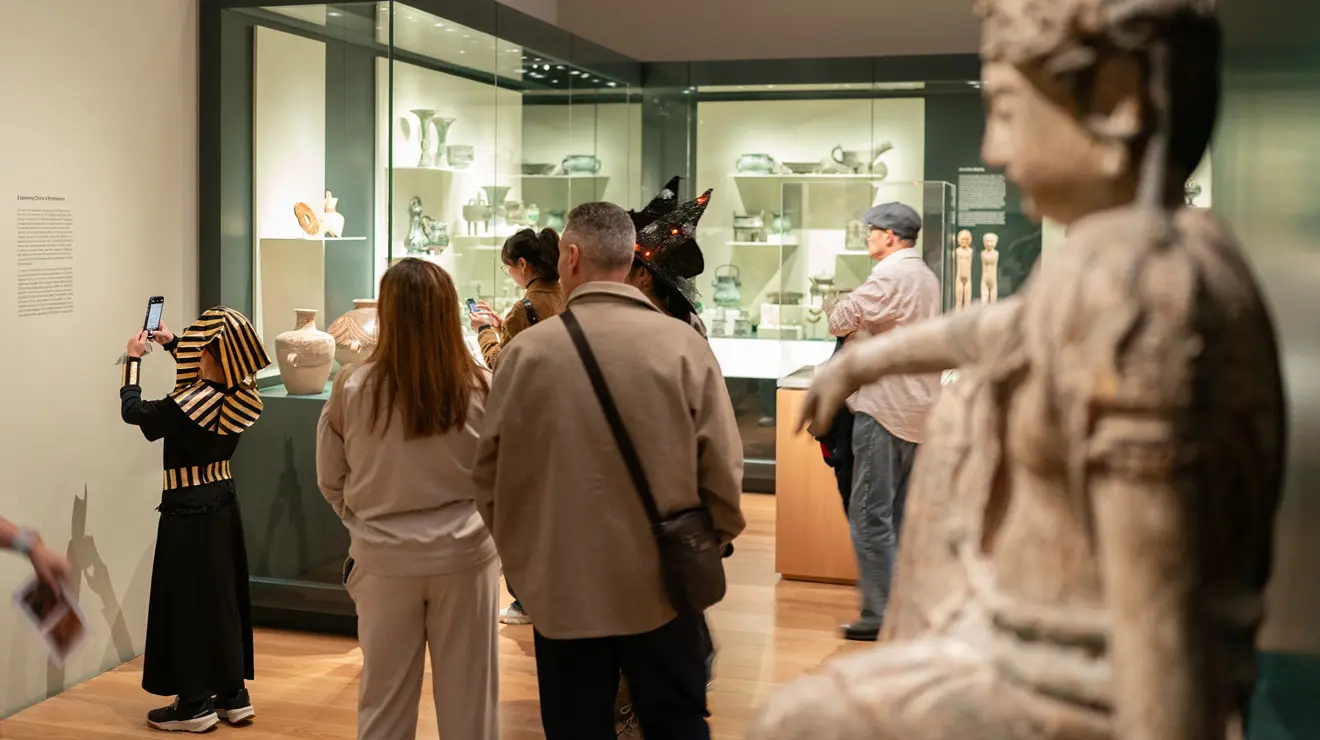 PAUM OPENING_Little Tut.jpg A child dressed as King Tut takes a photo of the description for a piece of art in the Princeton University Art Museum.