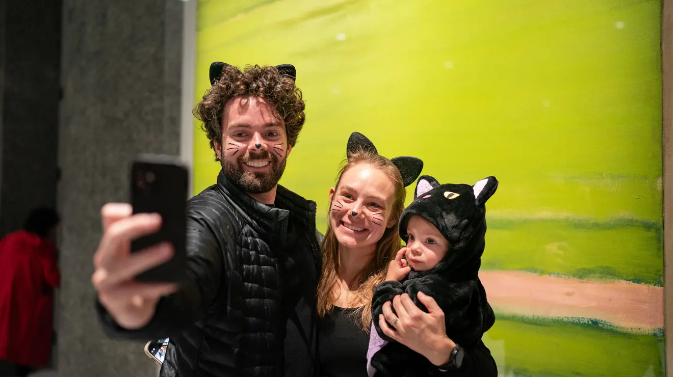 PAUM OPENING_Stella Cat Family.jpg A man, woman and child dressed as black cats pose on front of a Frank Stella painting at opening night of the Princeton University Art Museum.