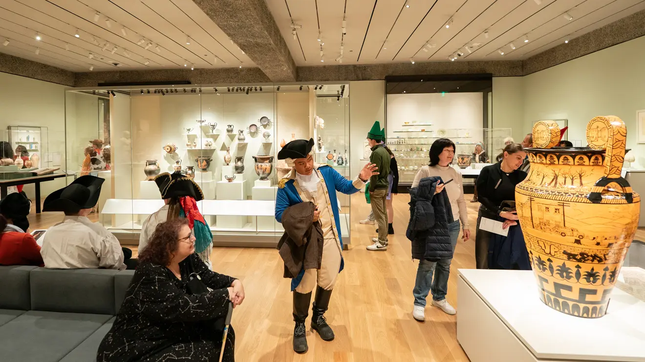 PAUM OPENING_Tri Corner Hat.jpg A man in a tri-corner hat and colonial garb admires a vase during opening night at the Princeton University Art Museum.